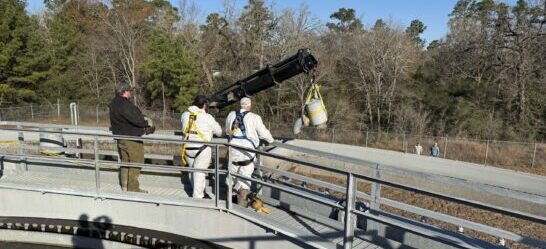 Technician performing maintenance on wastewater treatment equipment for Premier Wastewater & Septic, LLC.